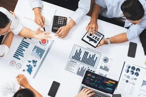 Analyst team utilizing BI Fintech to analyze financial data at table. Prudent Stock Photos