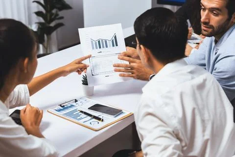 Analyst team utilizing BI Fintech to analyze financial data at table. Prudent Stock Photos