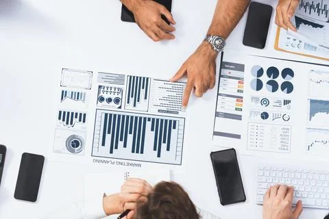 Analyst team utilizing BI Fintech to analyze financial data at table. Prudent Stock Photos