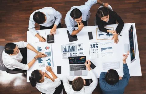 Analyst team utilizing BI Fintech to analyze financial data at table. Prudent Stock Photos