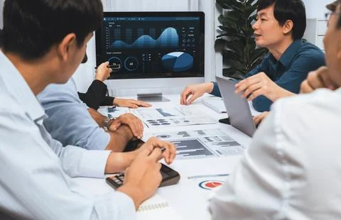 Analyst team utilizing BI Fintech to analyze financial data at table. Prudent Stock Photos