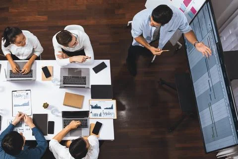 Analyst team utilizing BI Fintech to analyze financial data at table. Prudent Stock Photos