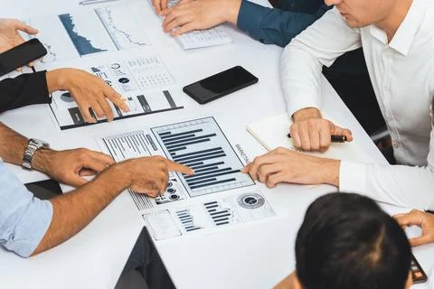 Analyst team utilizing BI Fintech to analyze financial data at table. Prudent Stock Photos