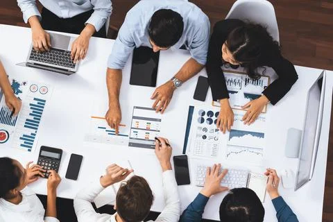Analyst team utilizing BI Fintech to analyze financial data at table. Prudent Stock Photos