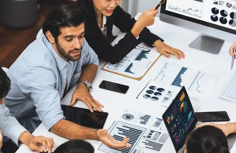 Analyst team utilizing BI Fintech to analyze financial data at table. Prudent Stock Photos