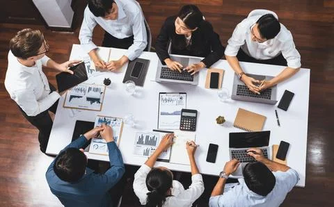Analyst team utilizing BI Fintech to analyze financial data at table. Prudent Stock Photos