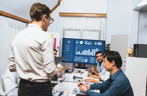 Analyst team utilizing BI Fintech to analyze financial data at table. Prudent Stock Photos