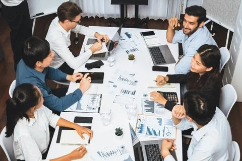 Analyst team utilizing BI Fintech to analyze financial data at table. Prudent Stock Photos