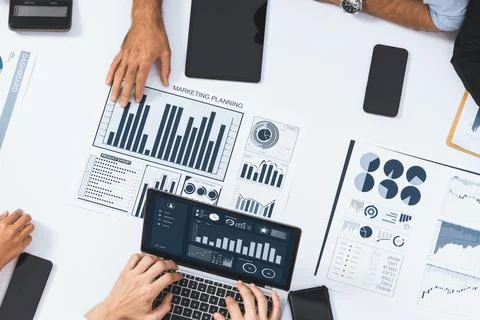 Analyst team utilizing BI Fintech to analyze financial data at table. Prudent Stock Photos