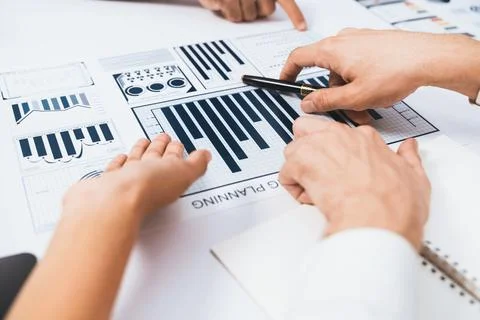 Analyst team utilizing BI Fintech to analyze financial data at table. Prudent Stock Photos