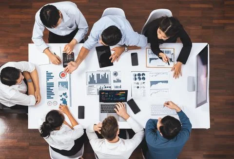 Analyst team utilizing BI Fintech to analyze financial data at table. Prudent Stock Photos