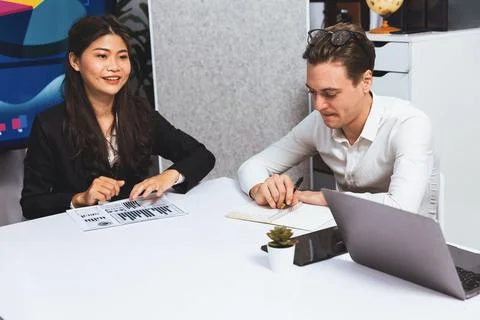 Analyst team utilizing BI Fintech to analyze financial data at table. Prudent Stock Photos