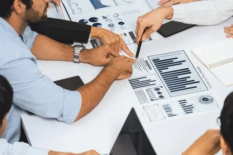 Analyst team utilizing BI Fintech to analyze financial data at table. Prudent Stock Photos
