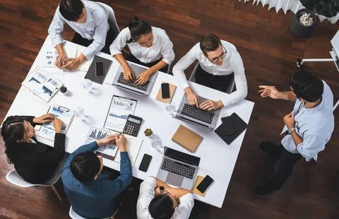 Analyst team utilizing BI Fintech to analyze financial data at table. Prudent Stock Photos