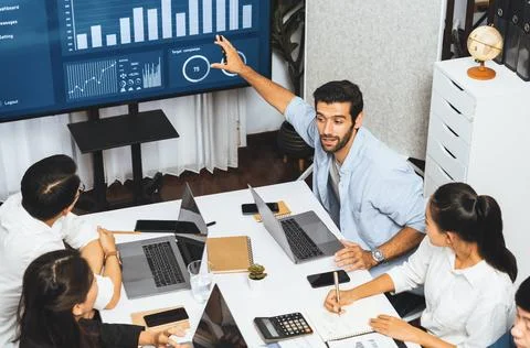 Analyst team utilizing BI Fintech to analyze financial data at table. Prudent Stock Photos