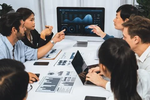 Analyst team utilizing BI Fintech to analyze financial data at table. Prudent Stock Photos