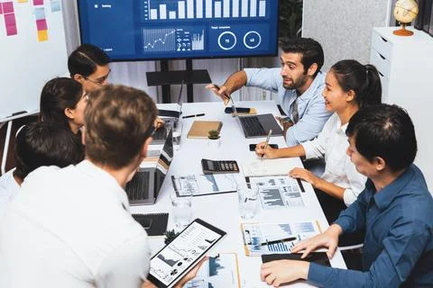 Analyst team utilizing BI Fintech to analyze financial data at table. Prudent Stock Photos