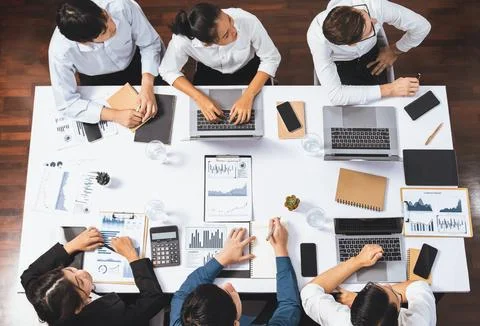 Analyst team utilizing BI Fintech to analyze financial data at table. Prudent Stock Photos
