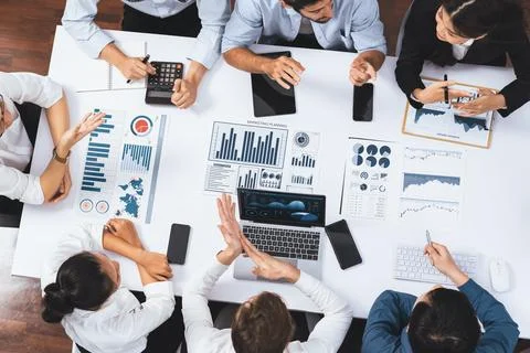 Analyst team utilizing BI Fintech to analyze financial data at table. Prudent Stock Photos