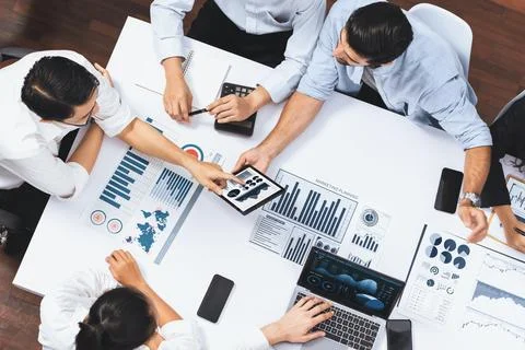 Analyst team utilizing BI Fintech to analyze financial data at table. Prudent Stock Photos