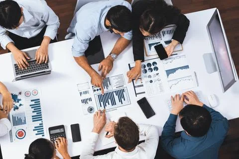Analyst team utilizing BI Fintech to analyze financial data at table. Prudent Stock Photos
