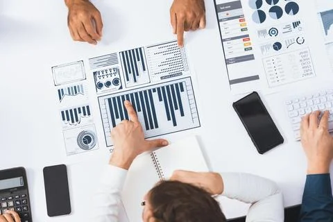 Analyst team utilizing BI Fintech to analyze financial data at table. Prudent Stock Photos