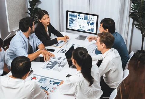 Analyst team utilizing BI Fintech to analyze financial data at table. Prudent Stock Photos