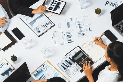 Analyst team utilizing BI Fintech to analyze financial data at table. Prudent Stock Photos