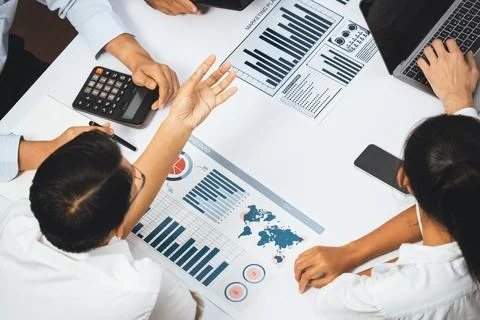 Analyst team utilizing BI Fintech to analyze financial data at table. Prudent Stock Photos