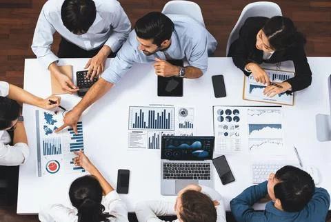 Analyst team utilizing BI Fintech to analyze financial data at table. Prudent Stock Photos