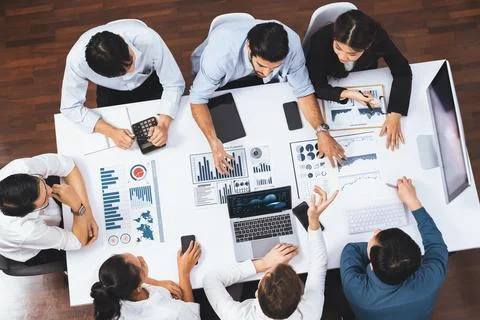 Analyst team utilizing BI Fintech to analyze financial data at table. Prudent Stock Photos