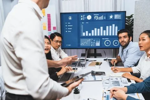 Analyst team utilizing BI Fintech to analyze financial data at table. Prudent Stock Photos