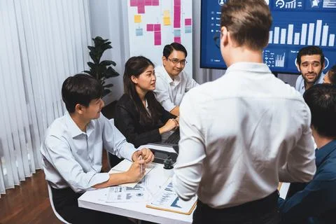 Analyst team utilizing BI Fintech to analyze financial data at table. Prudent Stock Photos