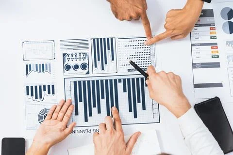 Analyst team utilizing BI Fintech to analyze financial data at table. Prudent Stock Photos