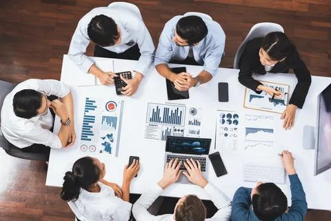 Analyst team utilizing BI Fintech to analyze financial data at table. Prudent Stock Photos