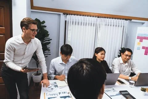 Analyst team utilizing BI Fintech to analyze financial data at table. Prudent Stock Photos