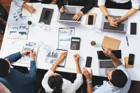 Analyst team utilizing BI Fintech to analyze financial data at table. Prudent Stock Photos