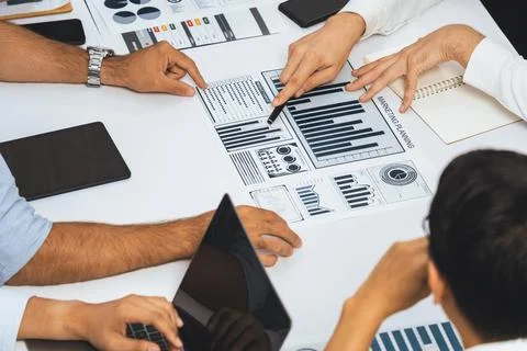Analyst team utilizing BI Fintech to analyze financial data at table. Prudent Stock Photos