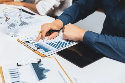 Analyst team utilizing BI Fintech to analyze financial data at table. Prudent Stock Photos