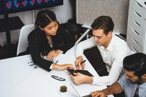 Analyst team utilizing BI Fintech to analyze financial data at table. Prudent Stock Photos