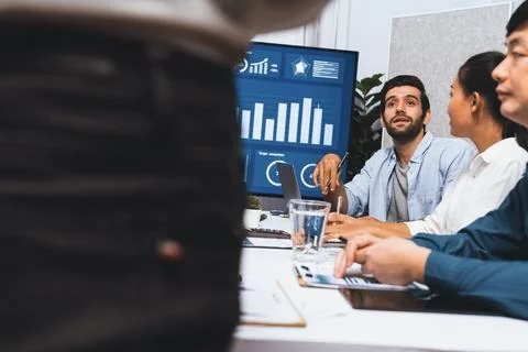 Analyst team utilizing BI Fintech to analyze financial data at table. Prudent Stock Photos