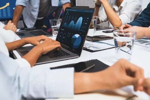 Analyst team utilizing BI Fintech to analyze financial data at table. Prudent Stock Photos