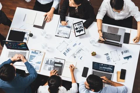 Analyst team utilizing BI Fintech to analyze financial data at table. Prudent Stock Photos
