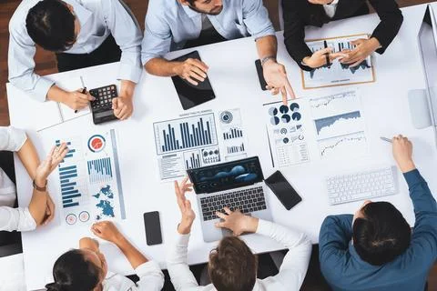 Analyst team utilizing BI Fintech to analyze financial data at table. Prudent Stock Photos