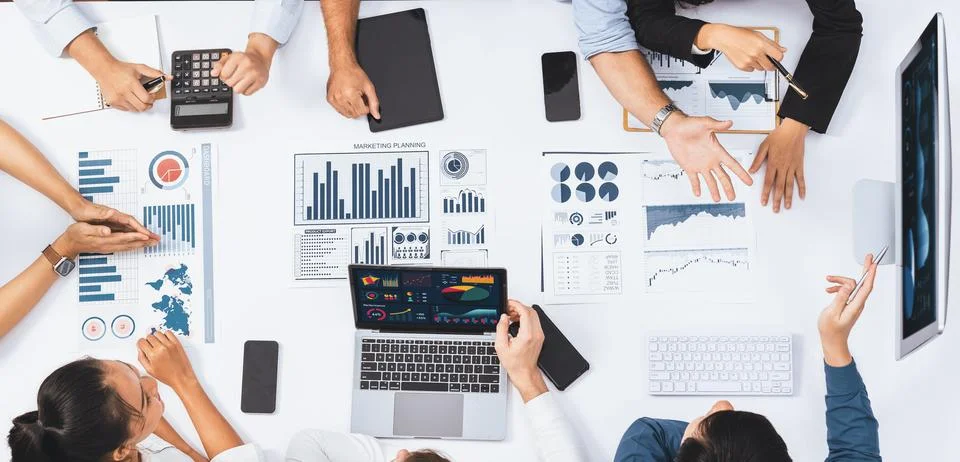 Analyst team utilizing BI Fintech to analyze financial data at table. Prudent Stock Photos