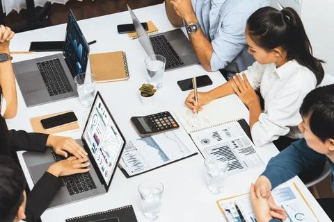 Analyst team utilizing BI Fintech to analyze financial data at table. Prudent Stock Photos