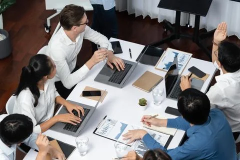 Analyst team utilizing BI Fintech to analyze financial data at table. Prudent Stock Photos