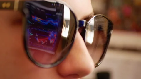 Analyst is viewing financial market data on a screen which reflects on glasses Stock Footage 163017989