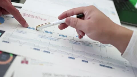 An analyst who analyzes and discusses financial data charts of listed compan Stock Footage 193994094
