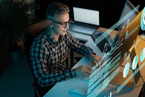 Analyst Working on Computer with Data and Graphs on Screen Stock Photos
